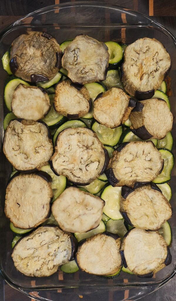 Second layer of roasted eggplant added to moussaka during assembly