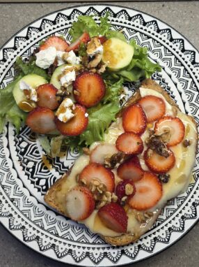 Brie and strawberry toast with honey and walnuts served with a fresh spring mix salad with goat cheese