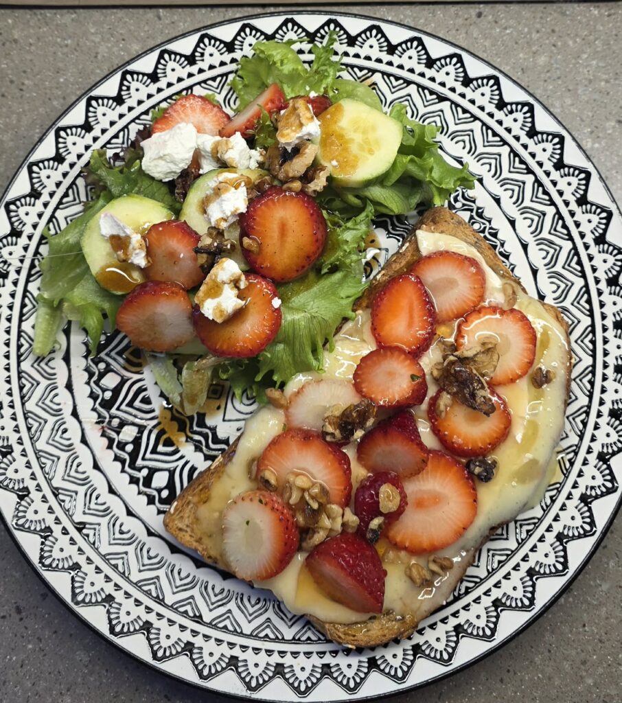 Brie and strawberry toast with honey and walnuts served with a fresh spring mix salad with goat cheese