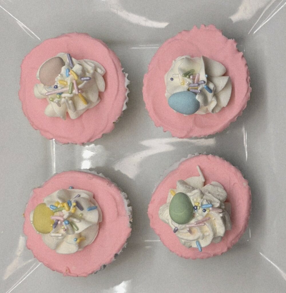 Overhead view of pastel mini no-bake cheesecakes topped with whipped cream and mini eggs