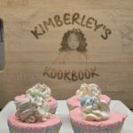 Mini no-bake Easter cheesecakes with pastel layers and whipped cream topping on a wooden board