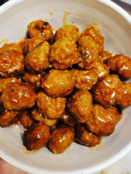 Sweet and sour meatballs coated in homemade sauce served as a party appetizer